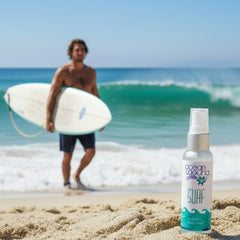 Ocean Laguna Surf hydrating body mist bottle on a beach with ocean waves